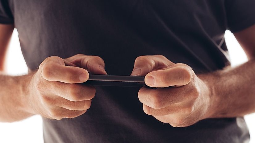 man playing mobile game on smartphone